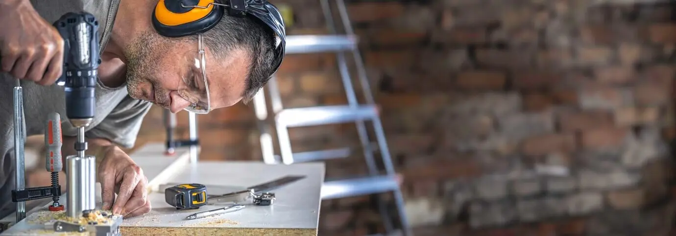 Der Tischler arbeitet mit einem professionellen Präzisionsbohrwerkzeug.